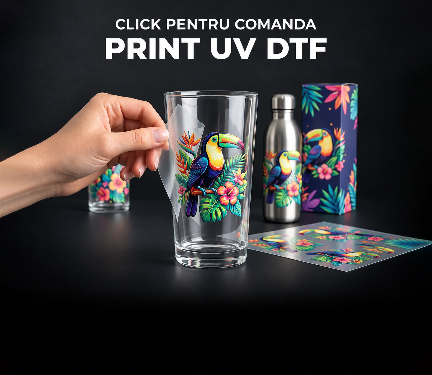 Aplicare transfer UV DTF cu tucan pe pahar, alaturi de o sticla metalica si o cutie personalizata